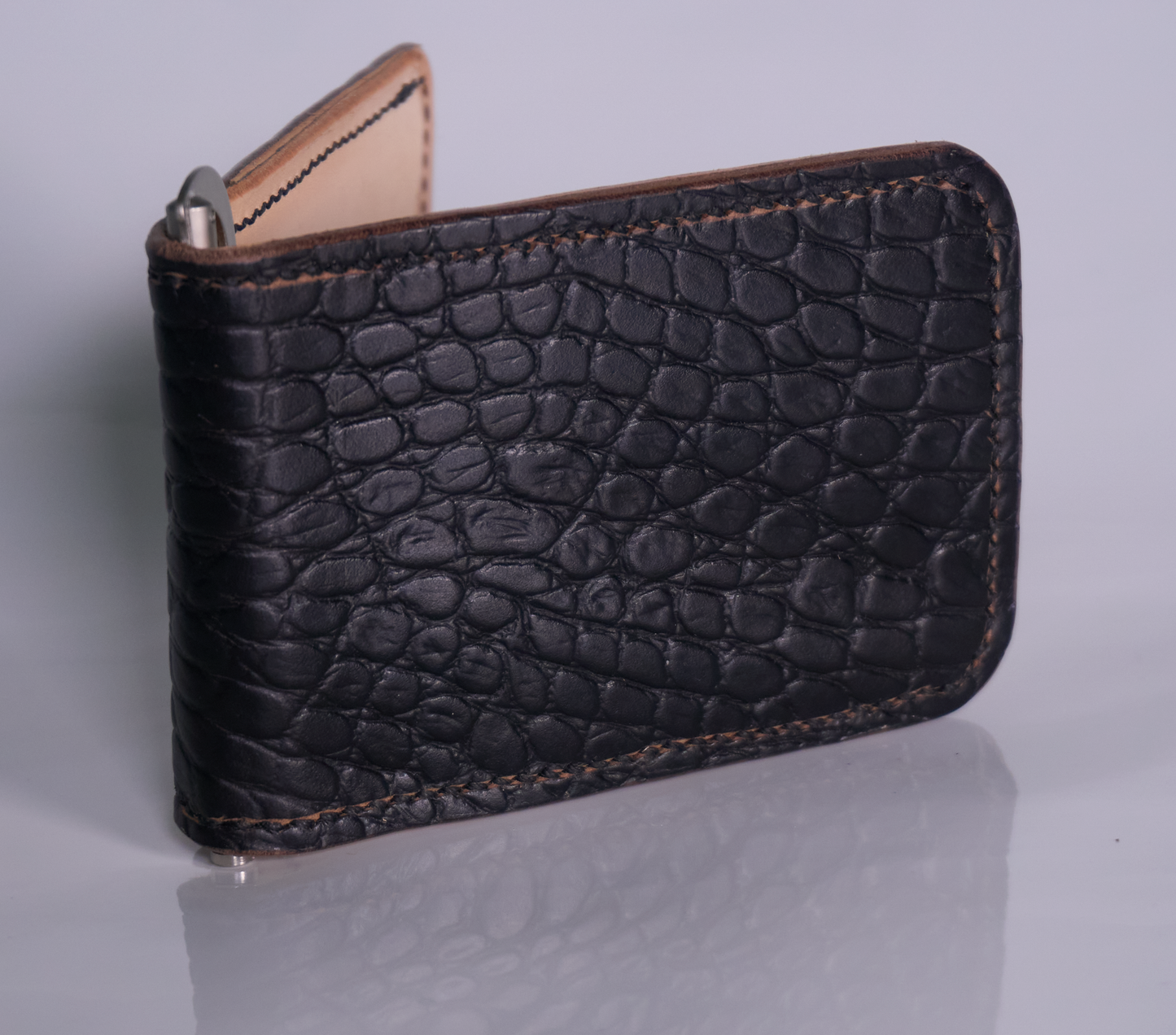 Exterior of black gator-embossed leather money clip with natural lining and silver money clip