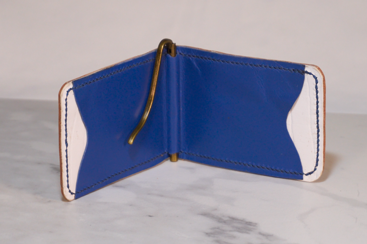 Interior of money clip with white kangaroon lining, blue kangaroo card pockets, and brass money clip