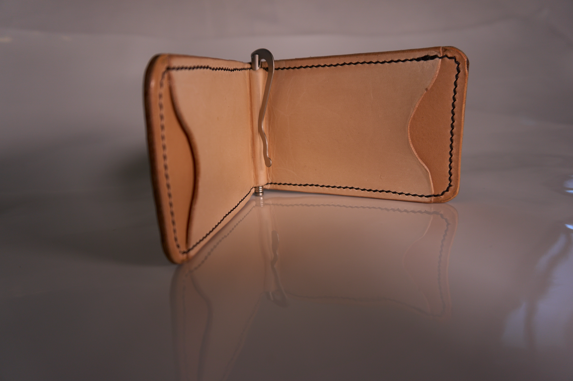 interior of money clip with natural leather lining, tan card pockets, and silver money clip