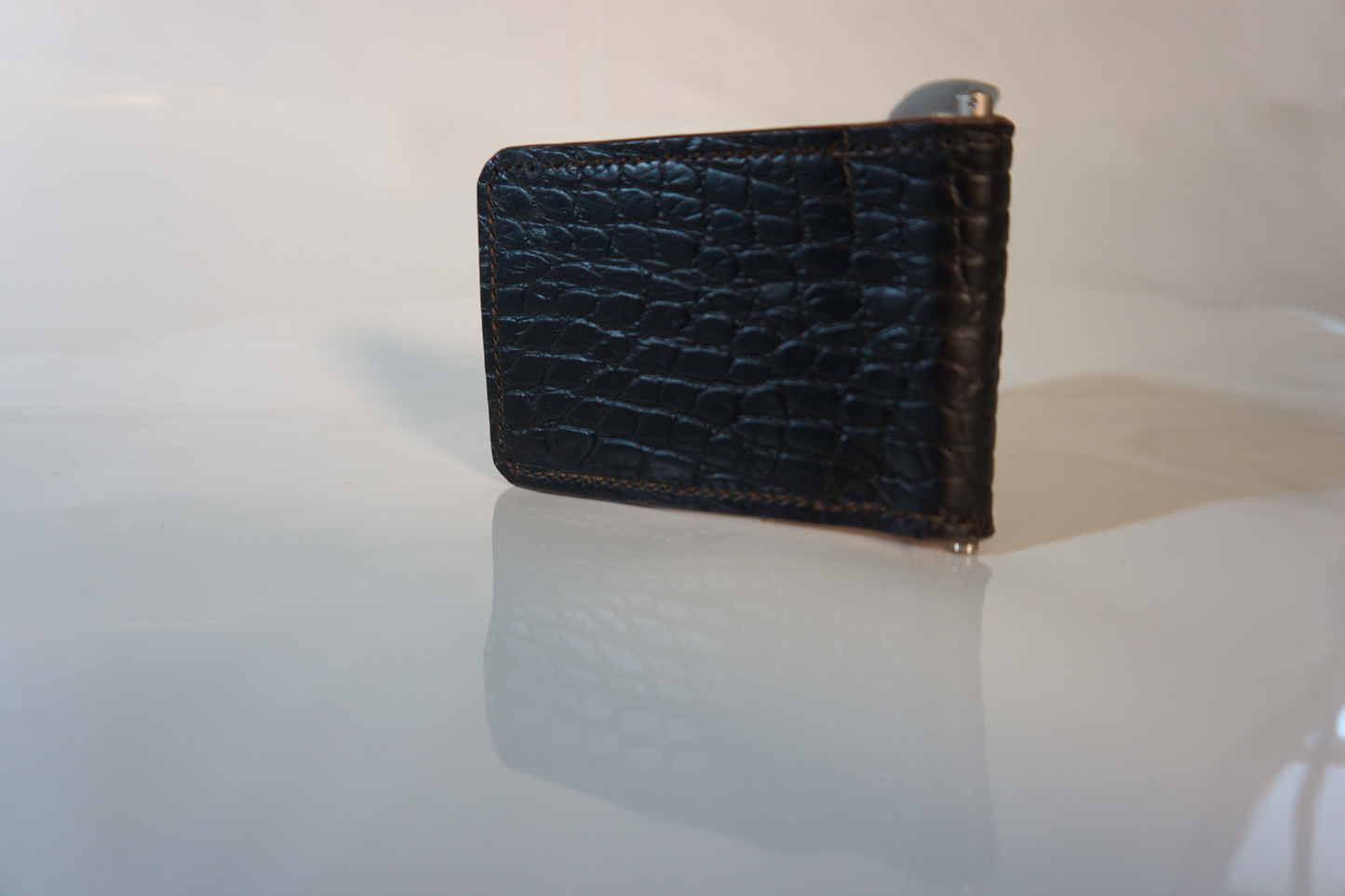 Exterior of money clip made of gator embossed cow leather with a silver money clip