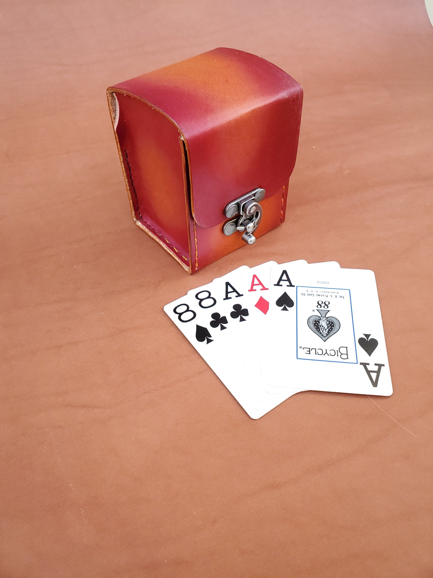 Red leather box with poker hand.