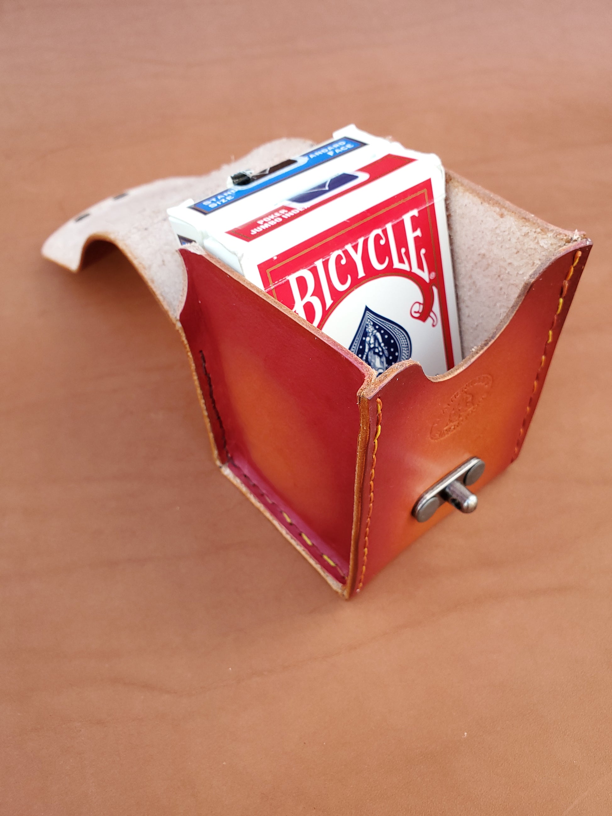 Top view of a red leather box with two packs of playing cards.
