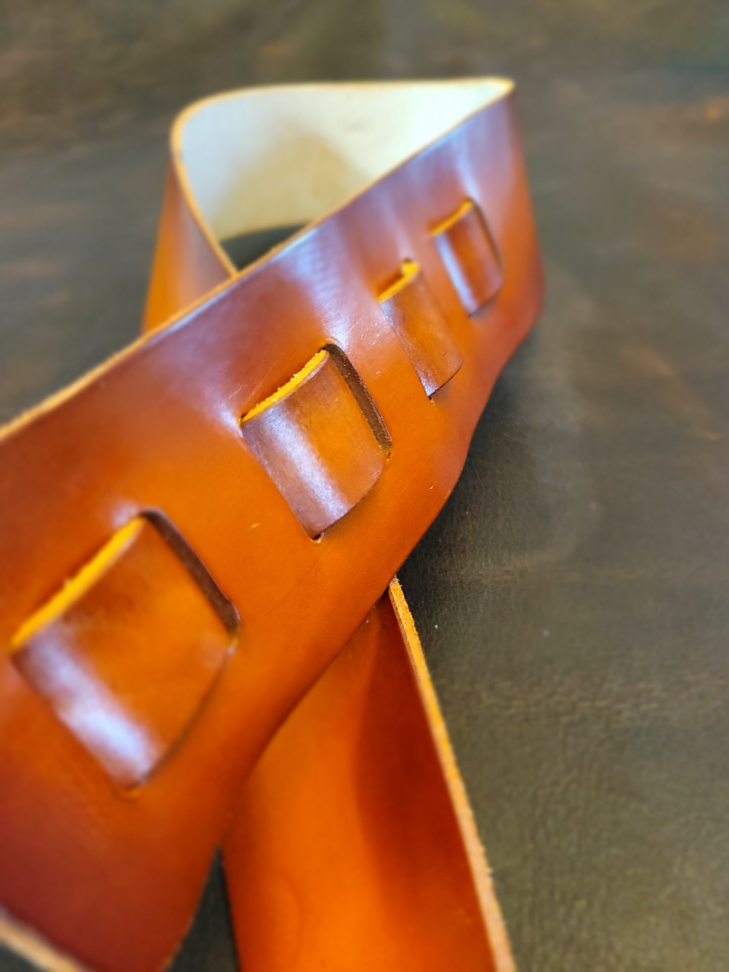 Top-grain leather guitar strap with Georgia rattlesnake inlay highlighting finish.