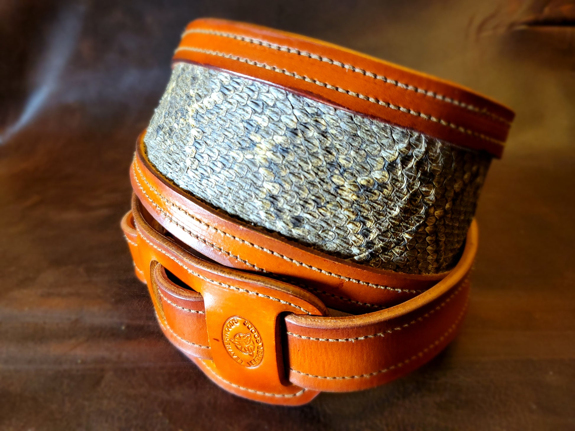 Top-grain leather guitar strap with Georgia rattlesnake inlay highlighting inlay and stitching