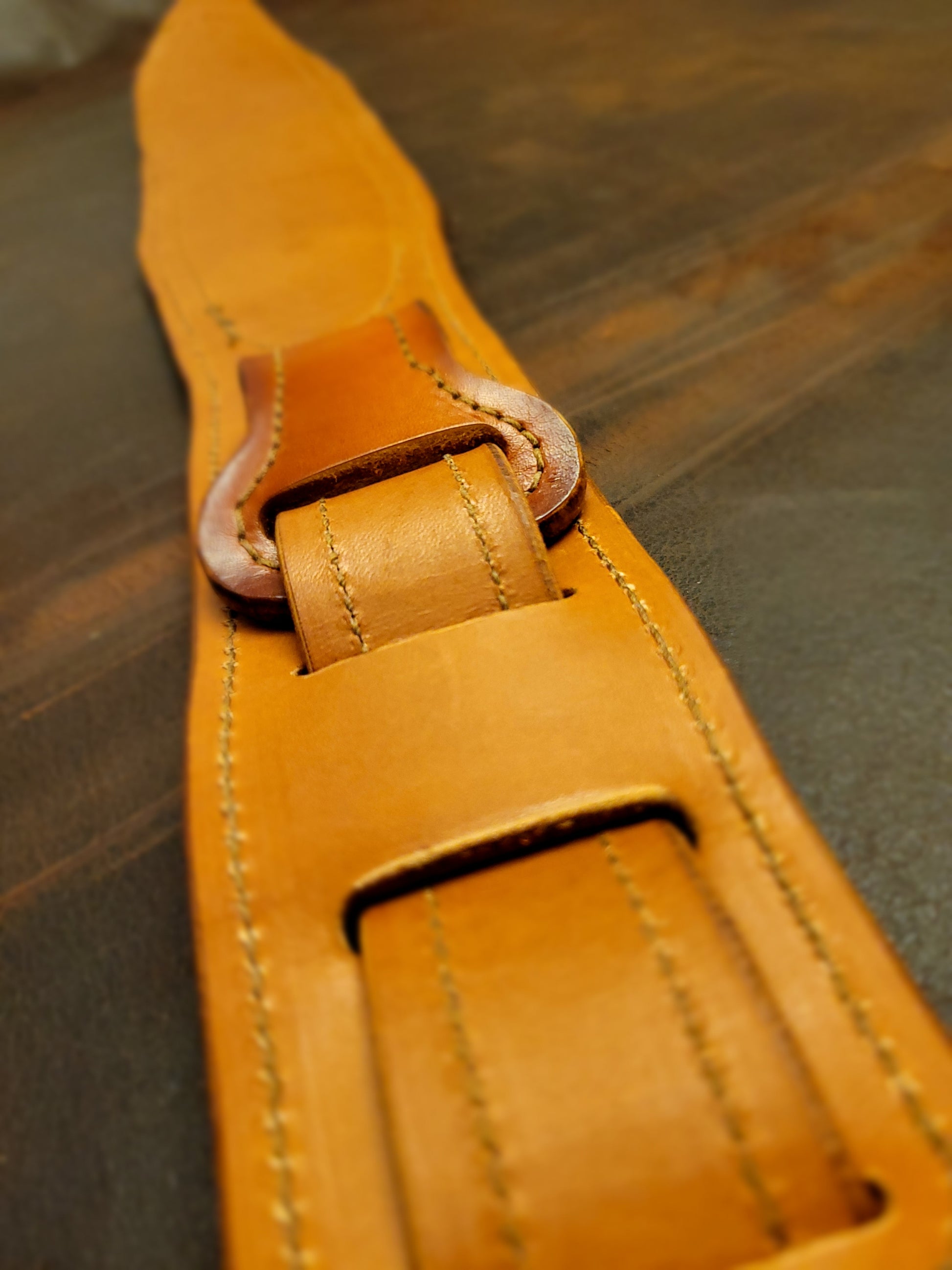 Top-grain leather guitar strap with Georgia rattlesnake inlay highlighting length adjustment strap.