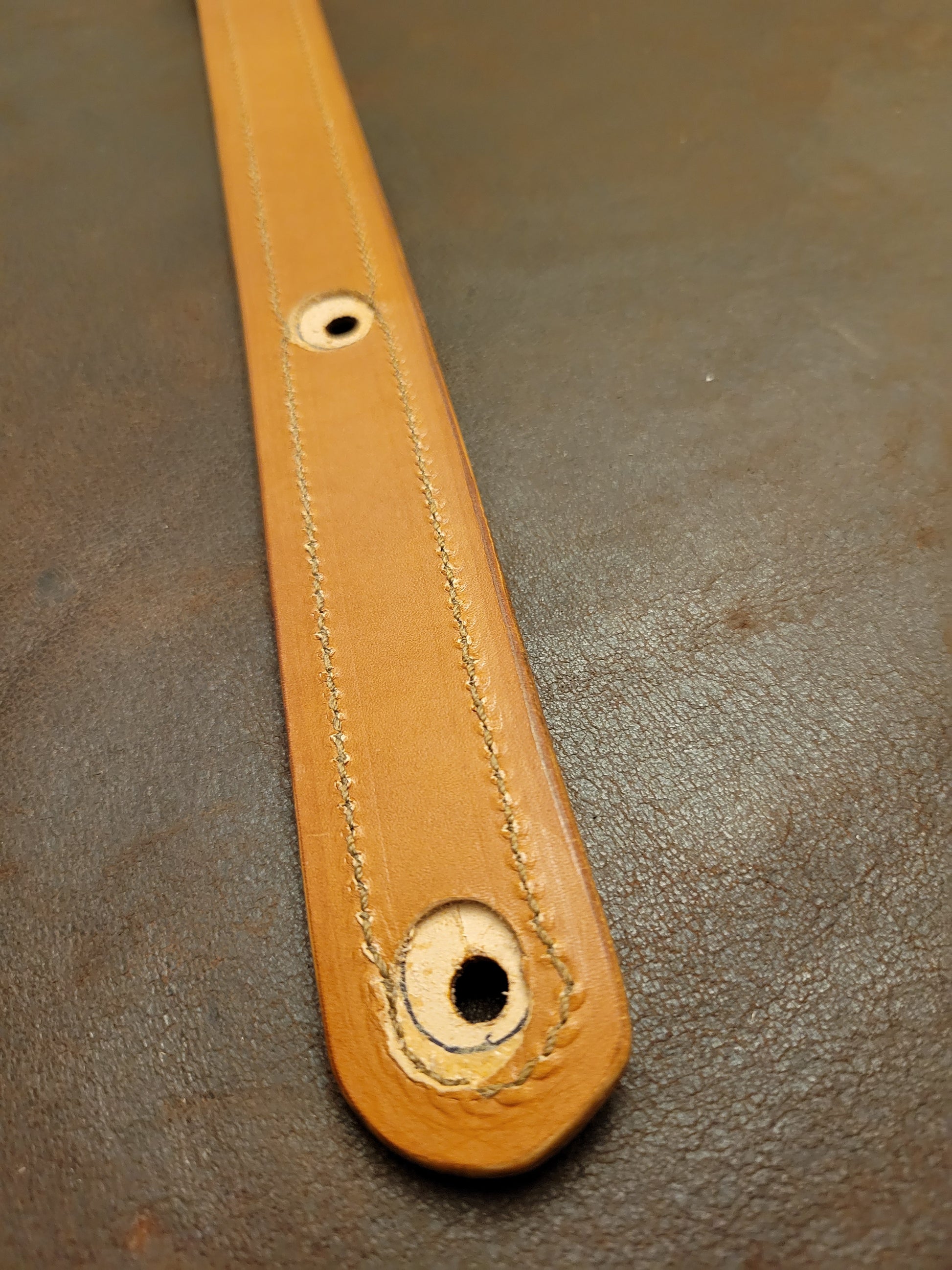 Top-grain leather guitar strap with Georgia rattlesnake inlay highlighting keyhole attachment point.