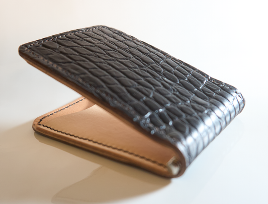 Closeup detail of money clip with gator embossed cow leather exterior, natural interior and tan card pockets showing texture highlights