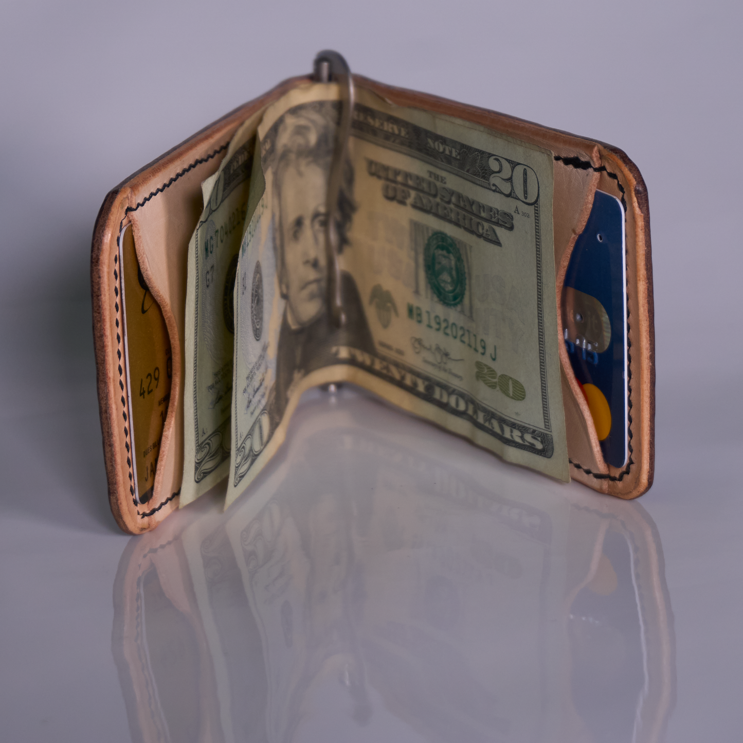 Money clip with tan exterior, natural lining, and two natural interior card pockets