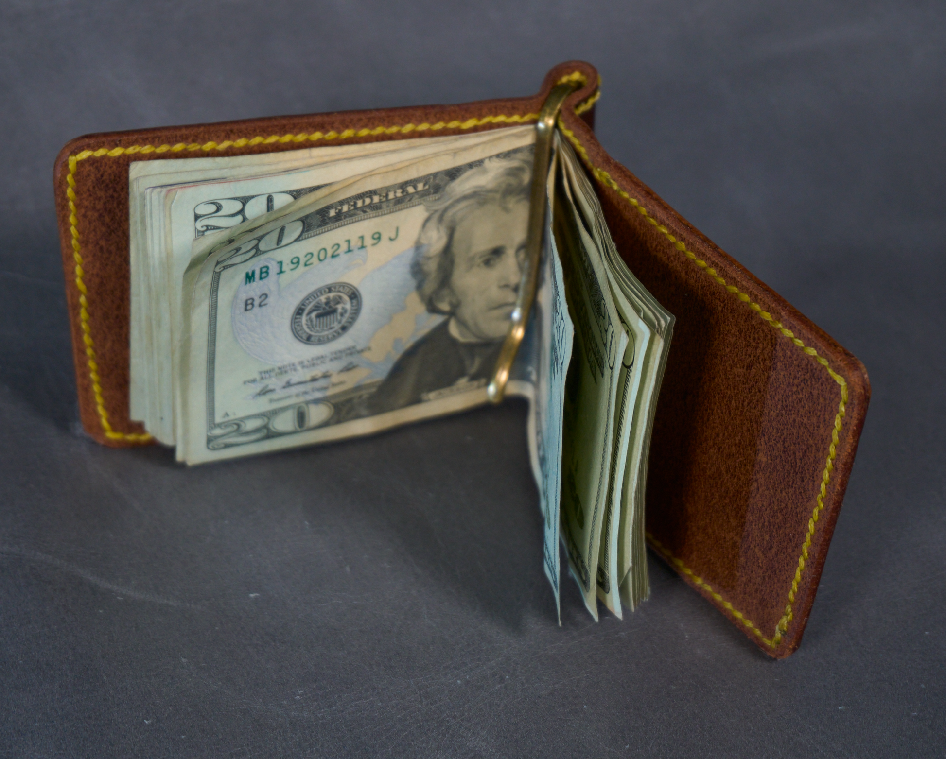 Money clip with brown exterior, natural interior, and contrasting yellow stitching