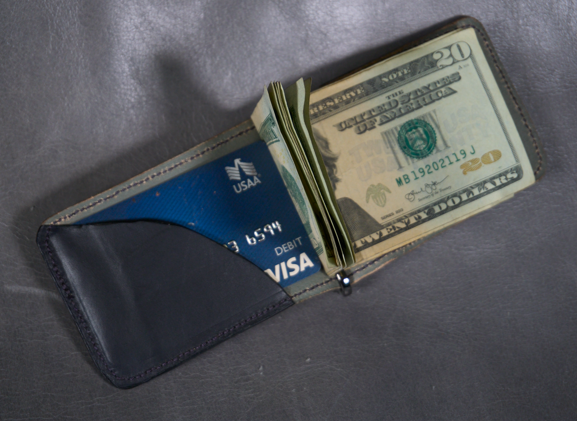 Interior of money clip with elephant ear exterior, grey lining and one black interior card pocket 